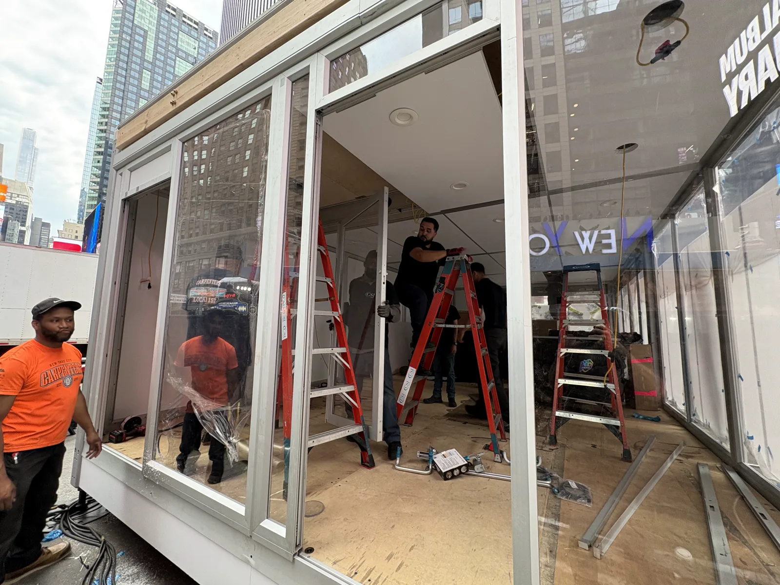 Crew installing glazing and enclosure details on the activation