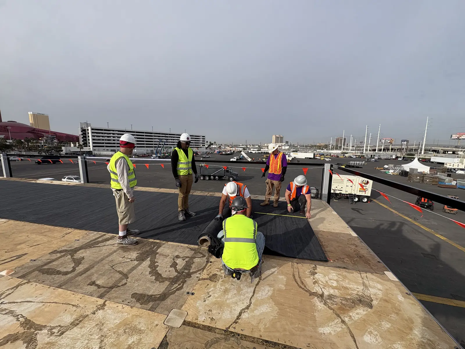 Crew installing roof deck material during the Volvo CONEXPO build